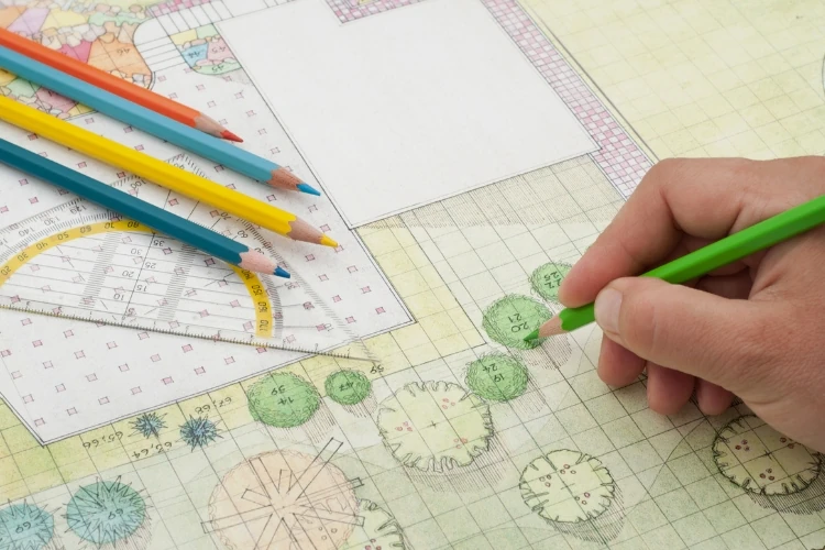 Landscape design plan with colored pencils, ruler, and hand sketching garden layout