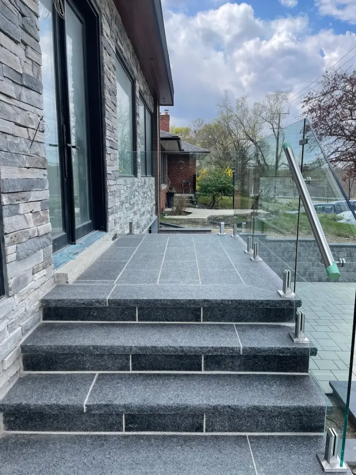 modern stone steps with glass railing and front porch landing in contemporary home