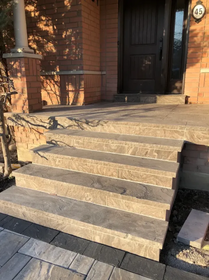 natural stone front porch steps with textured finish leading to residential entryway