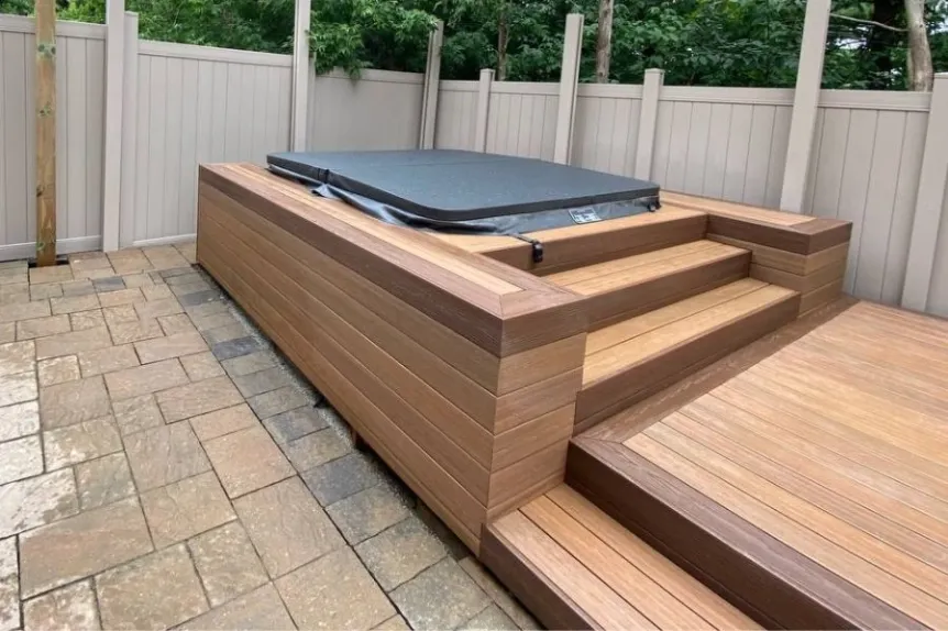 Built-in hot tub platform with wood steps and interlocking patio surface