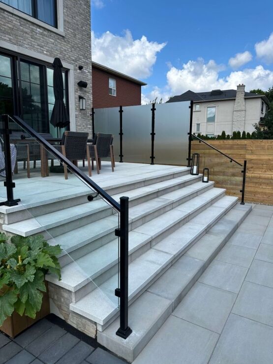 Interlocking Stone Steps Into Backyard Backyard railing and patio with interlocking stone, image by Oaks Home Services