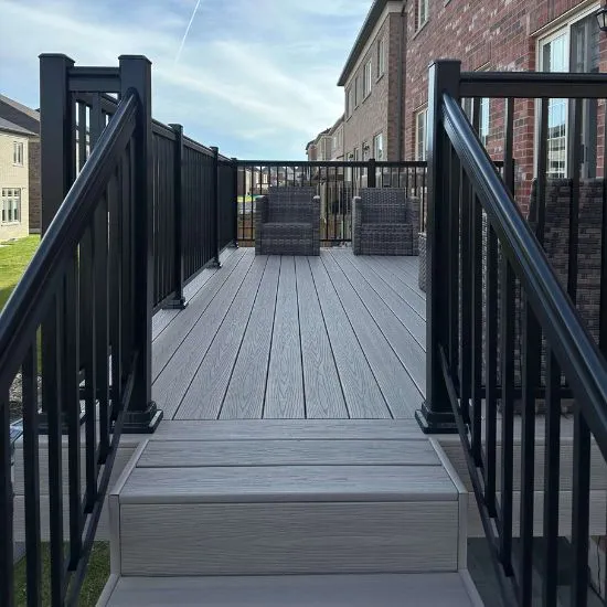 Composite deck with black railing and steps showcasing deck construction design