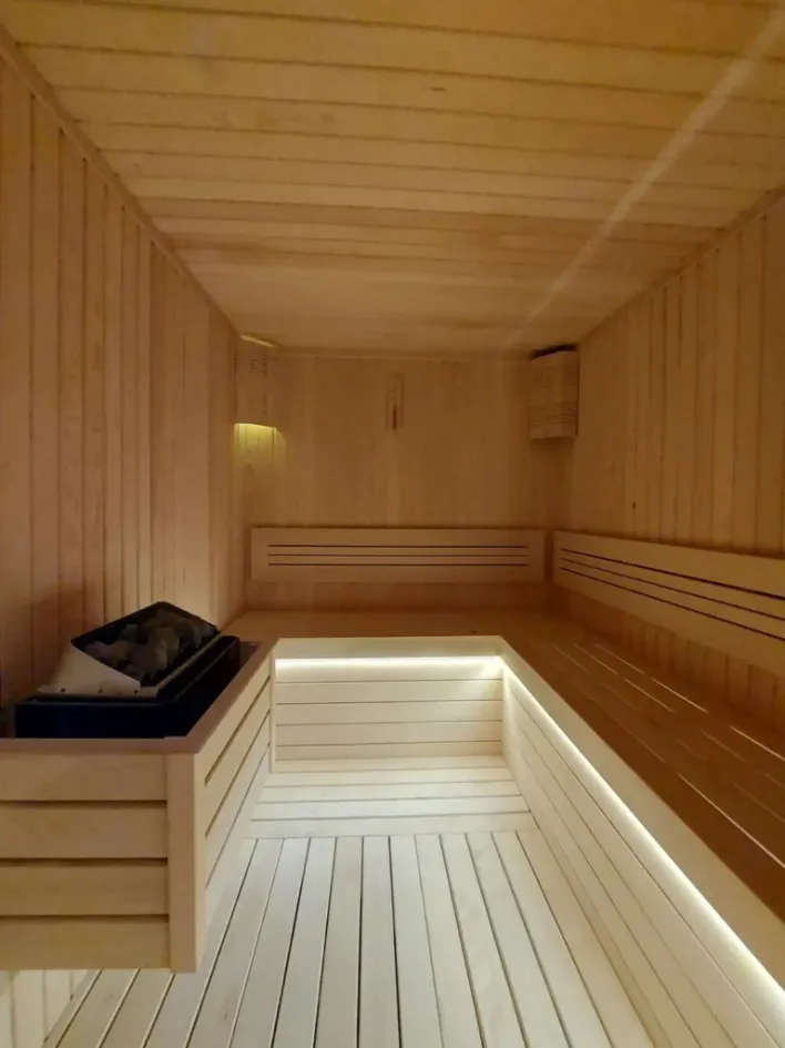 Compact home sauna with an electric heater and illuminated benches, photo by Oaks