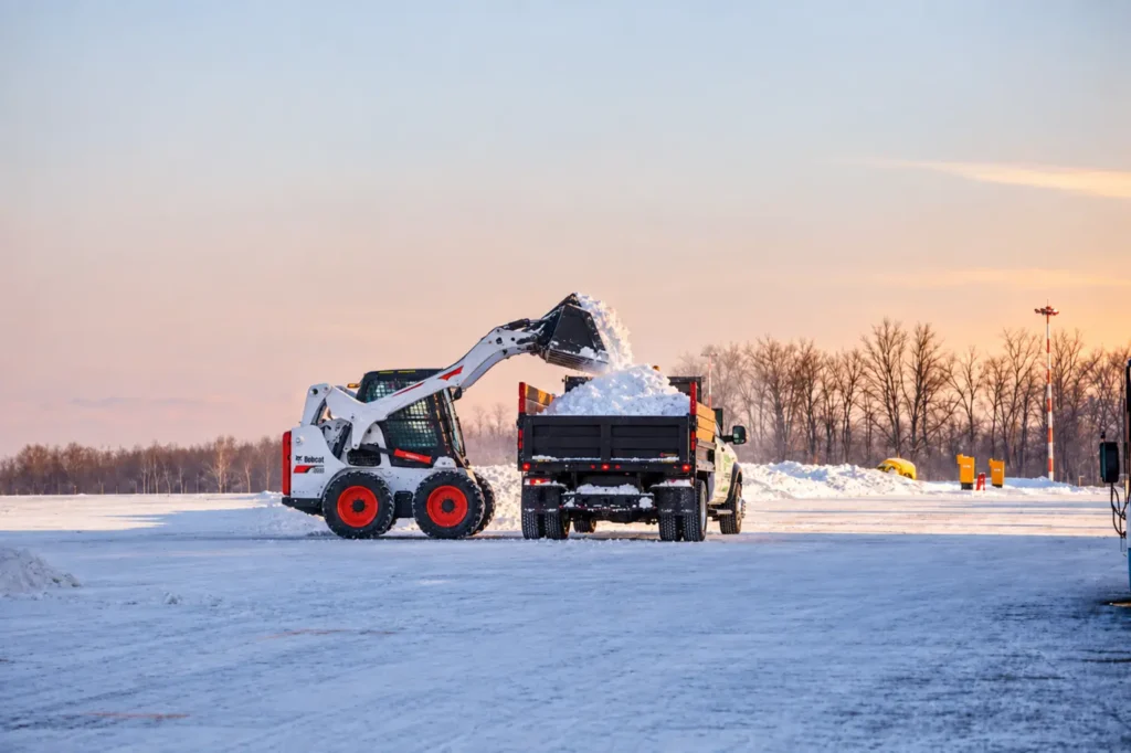 Oaks Bobcat S650 loading snow into a RAM 5500 dump truck, photo by Oaks