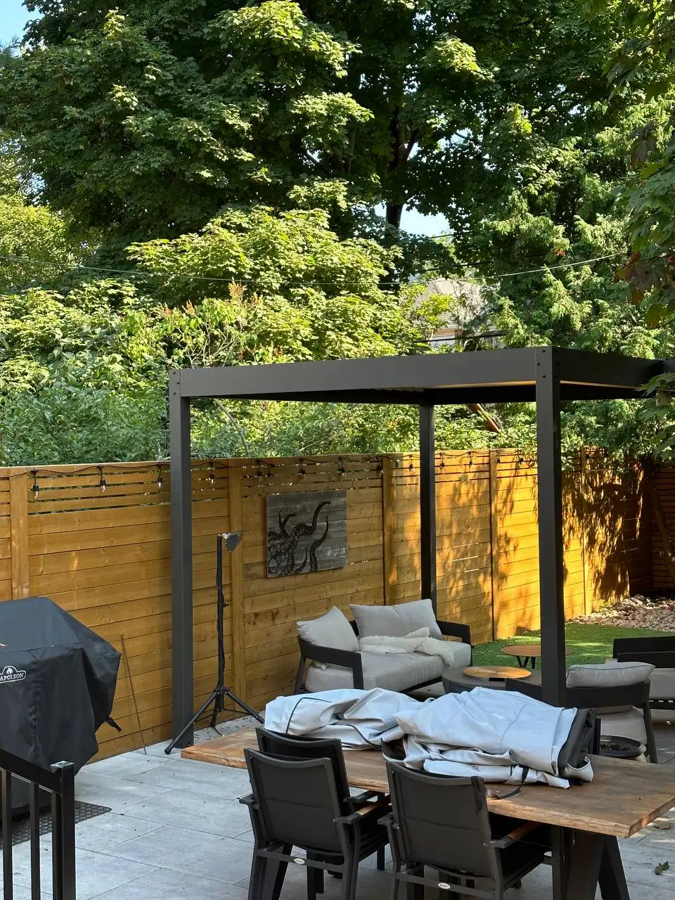 backyard patio with pergola seating area and horizontal wood privacy fence
