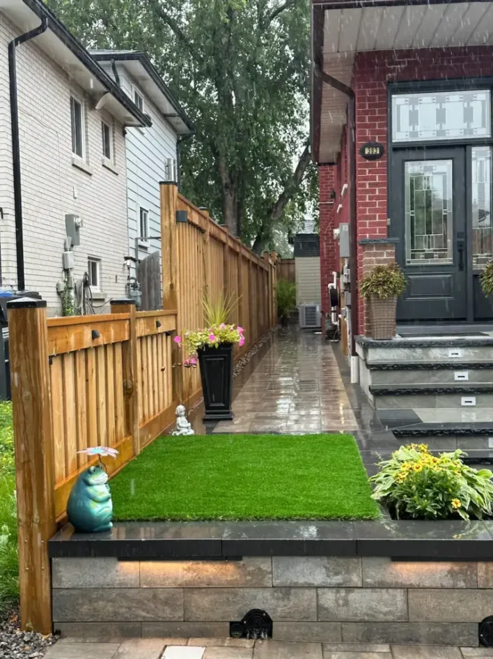 front yard retaining wall with artificial grass and wood privacy fence along side yard