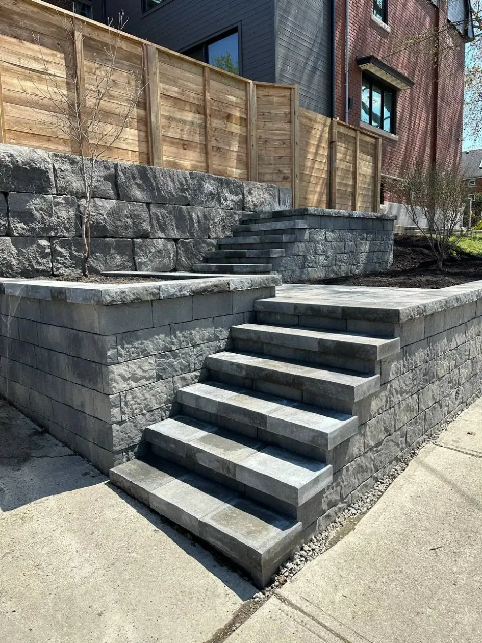interlocking stone steps with retaining wall and tiered landscape design in residential yard