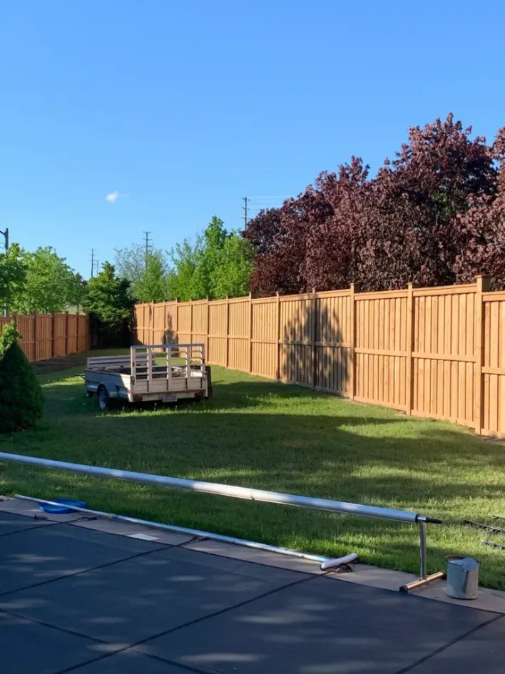 long wood privacy fence enclosing large backyard lawn area