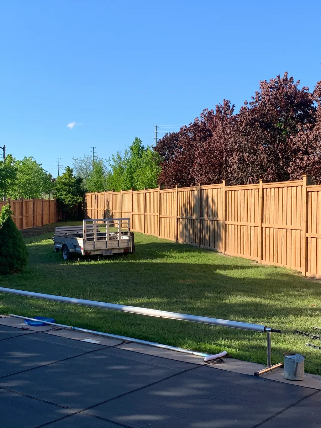 long wood privacy fence enclosing large backyard lawn area