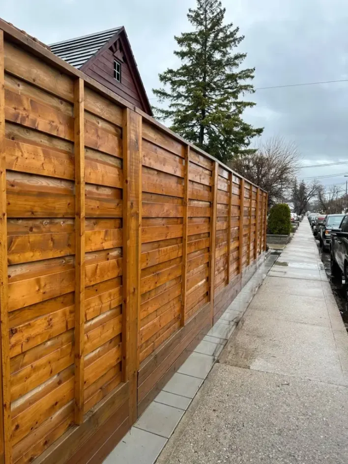 horizontal wood privacy fence along sidewalk with modern cedar panels
