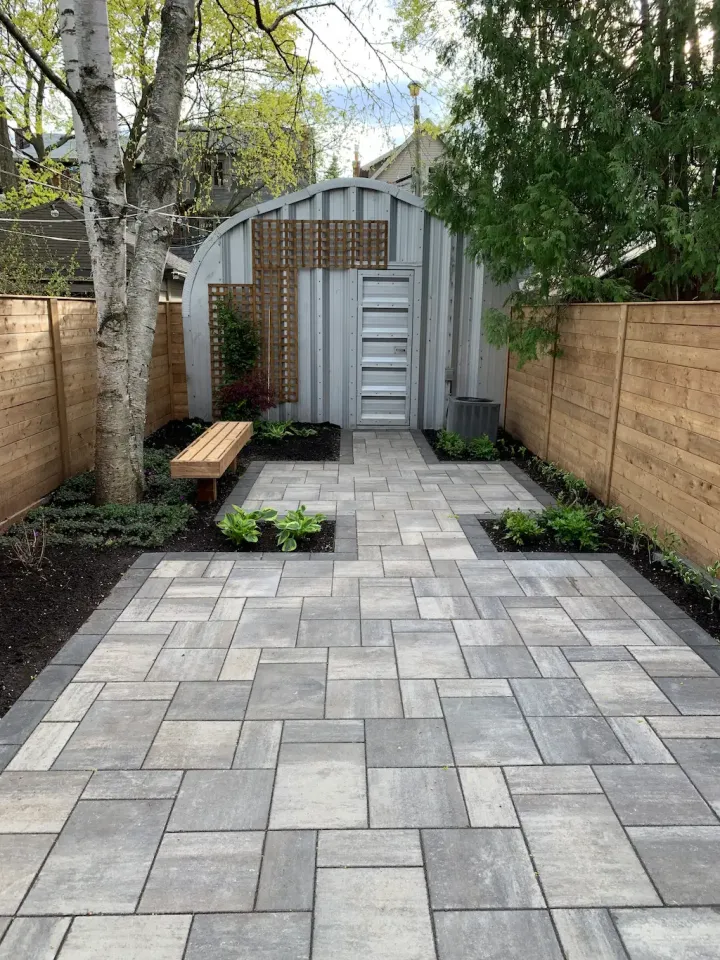 modern backyard patio with interlocking pavers, garden beds, and clean landscaping design