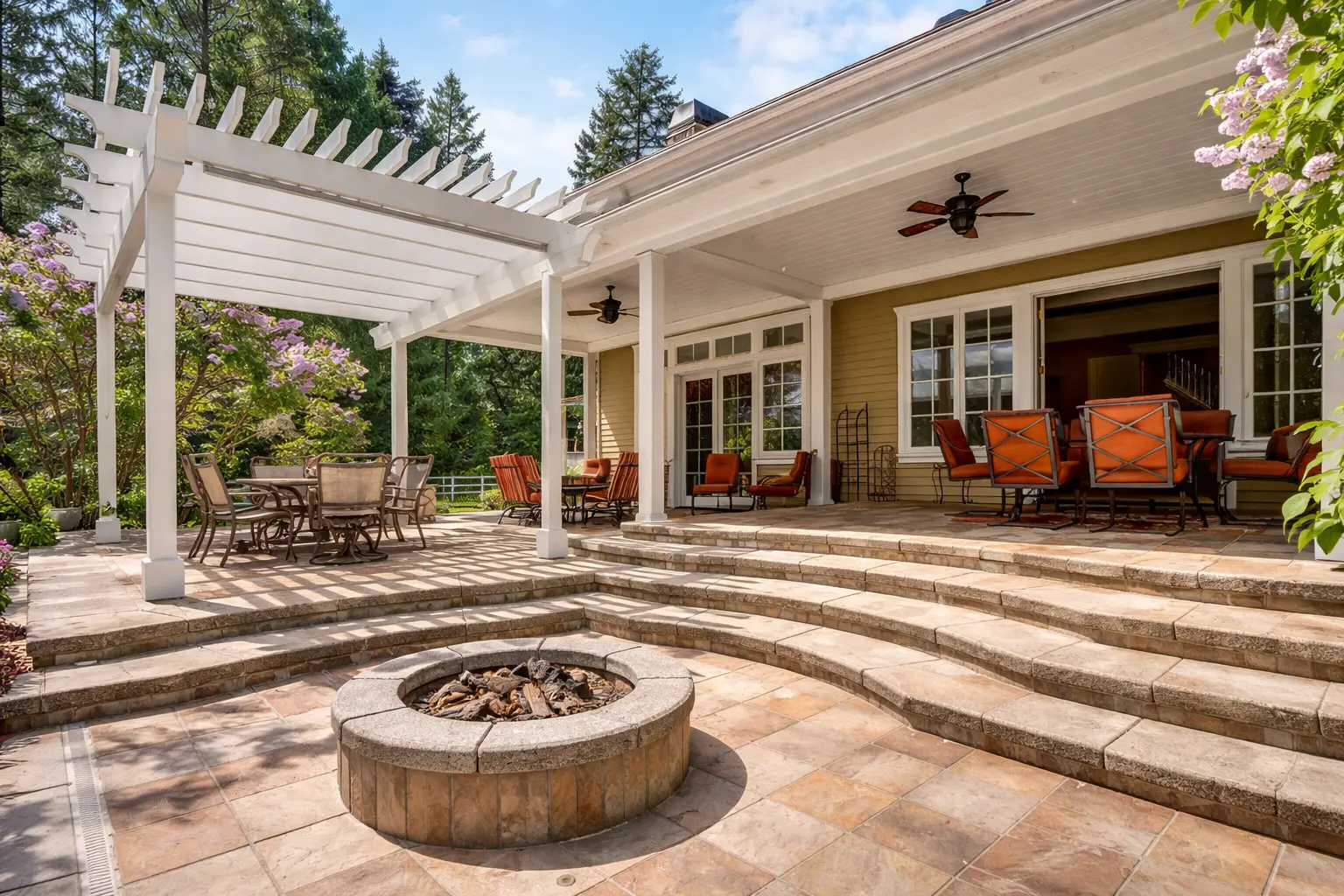 covered backyard patio with pergola seating area and stone fire pit on paved terrace