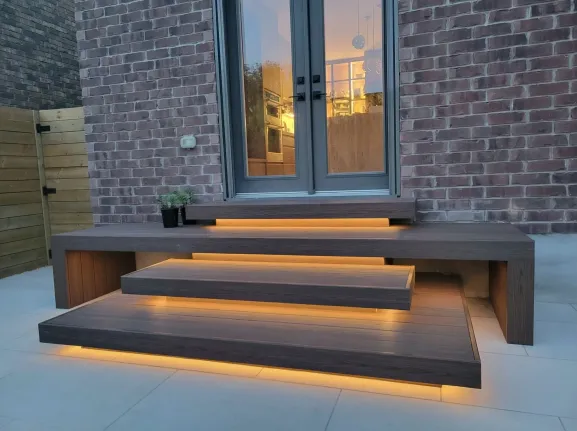 modern wood deck steps with built-in LED lighting leading to backyard patio door