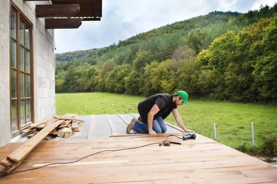 Professional deck builder installing wooden deck boards to increase home value and structural durability