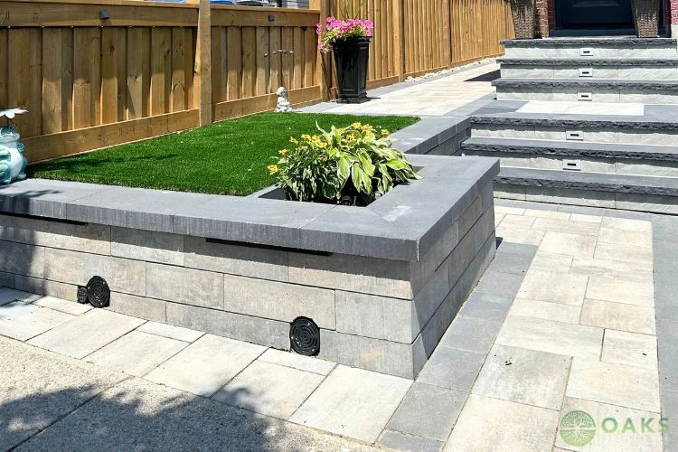 Modern retaining wall with raised garden bed and interlocking stone steps installation