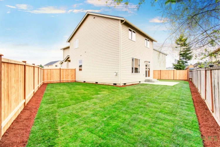 New wooden privacy fence enclosing residential backyard with fresh sod