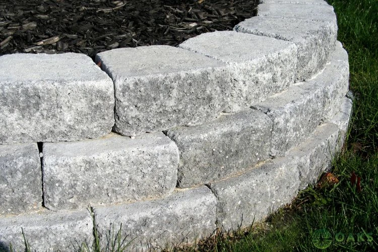 Close-up of curved stone retaining wall blocks in landscaped yard