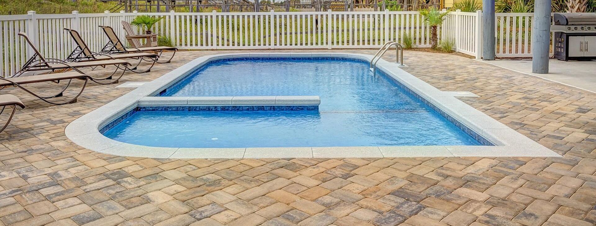 Pool interlock pavers in light beige laid in herringbone style, photo by Oaks Home Services