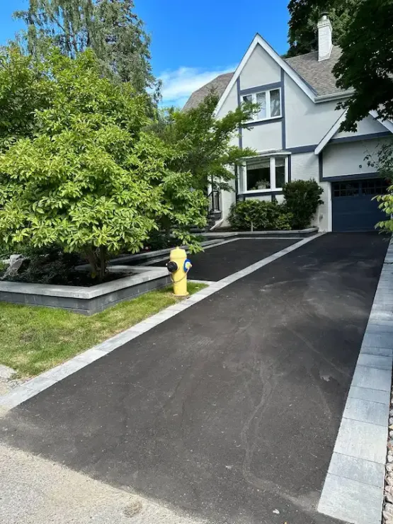 Asphalt driveway extension with stone border near trees, image by oakshs.ca