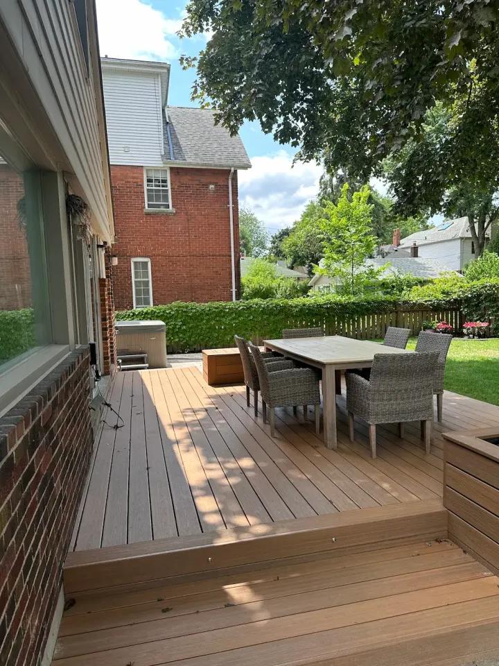 backyard wood deck with outdoor dining area and seating in landscaped yard