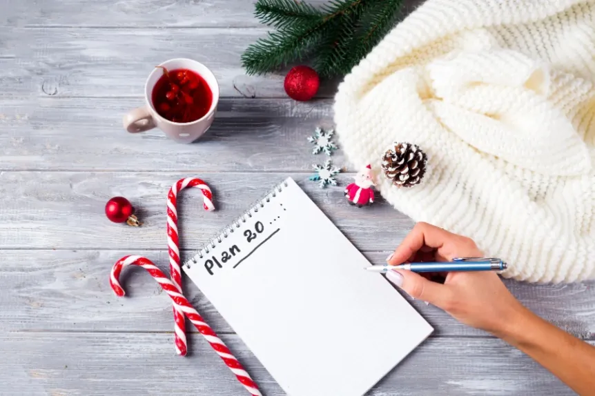 Winter planning setup with notebook and warm decor, symbolizing early preparation for spring landscaping
