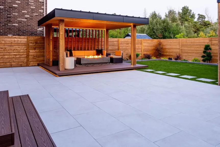 Modern patio with large format pavers, wood pergola, and built-in fire feature
