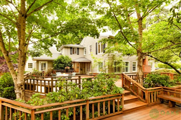 Multi-level wooden backyard deck with built-in planters and railing around family home
