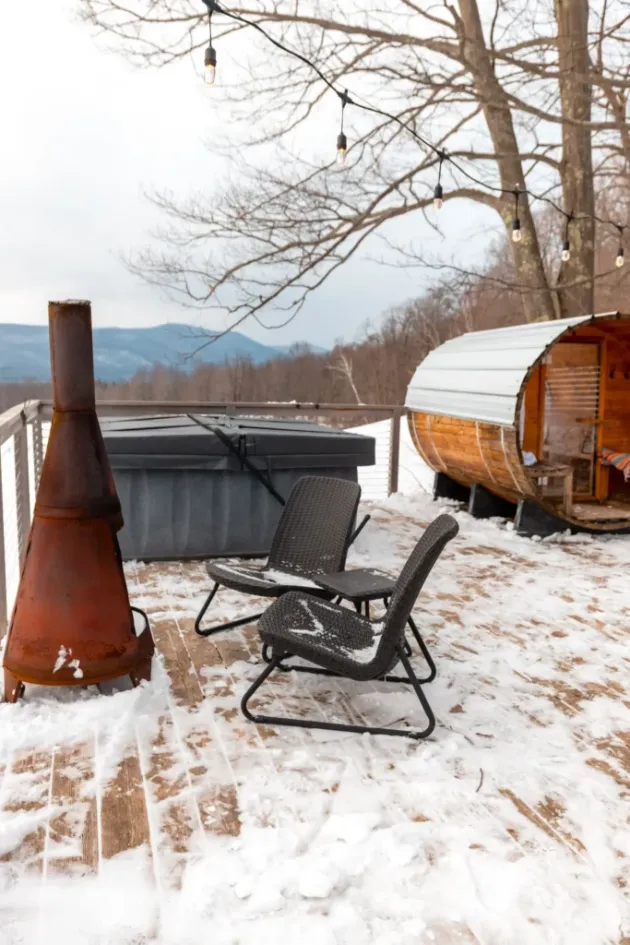Covered hot tub on a snowy deck with a barrel sauna and mountain view, photo by oakshs.ca