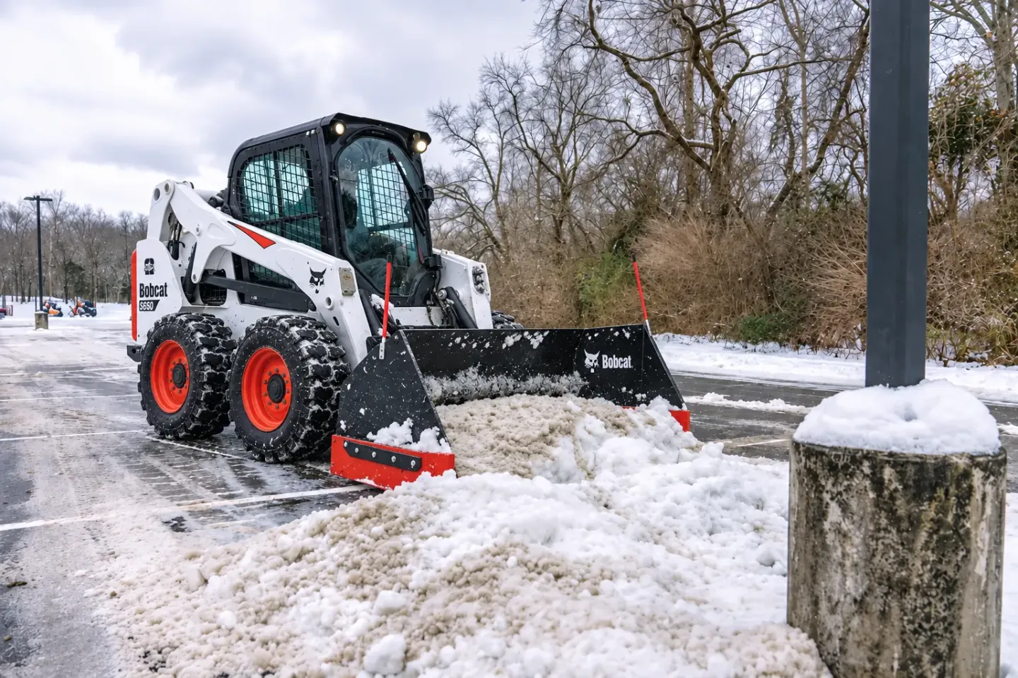 Oaks Bobcat S650 clearing a parking lot snow pile, photo by Oaks