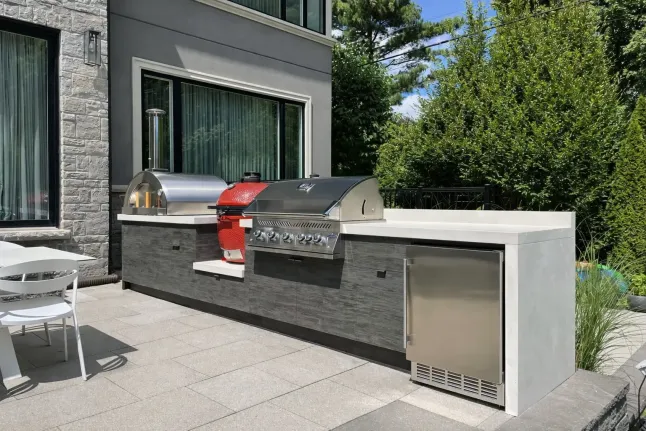 modern outdoor kitchen with built-in grill, pizza oven and stainless steel appliances on patio