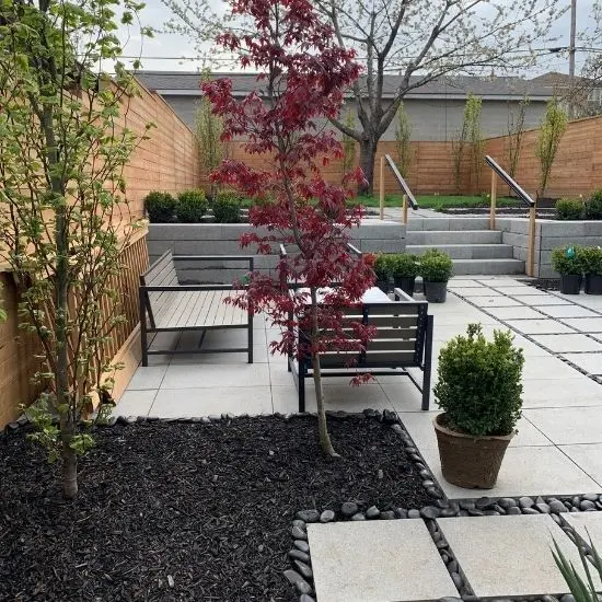 Backyard patio with large concrete stepping stones, raised planters, and garden landscaping design, image by OAKS Home Services