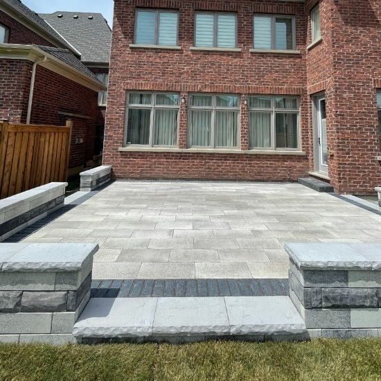 Image depicts a backyard with a new interlocking patio.