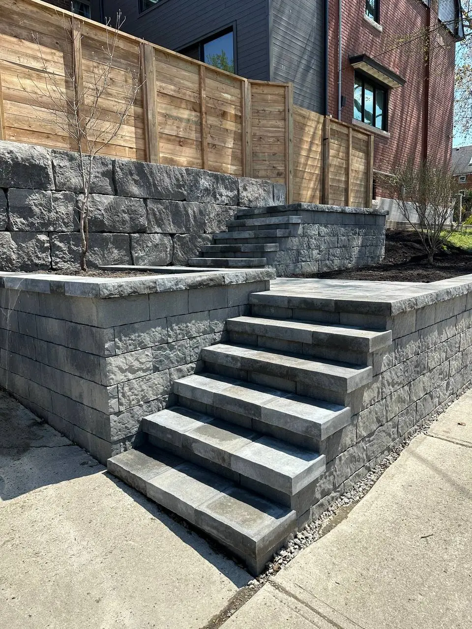 interlocking stone steps with retaining wall and tiered landscape design in residential yard