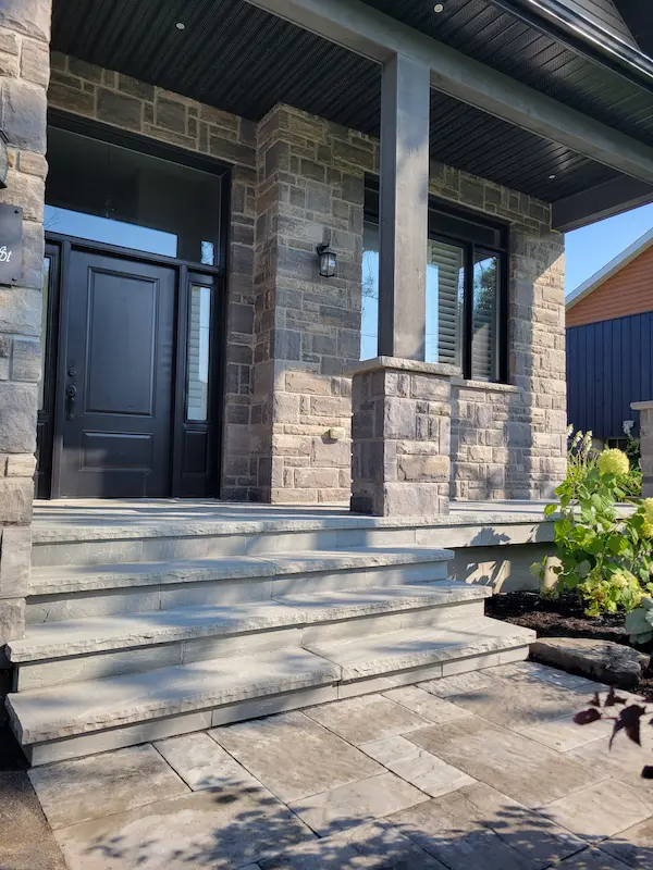 Custom stone front porch with tiered steps by porch team, image by oakshs.ca
