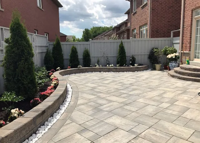 Backyard patio and planting beds by Oaks with clean stone finish