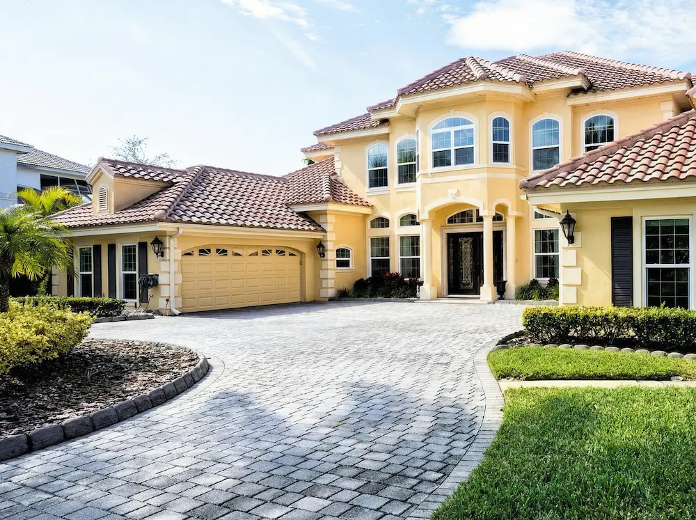 Luxury home with curved interlocking stone driveway and landscaped front yard