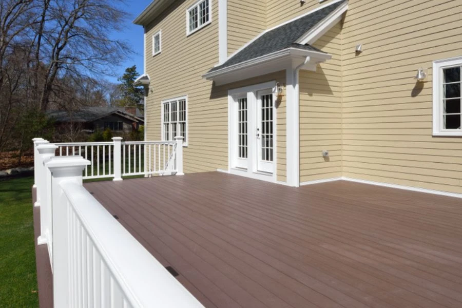 Spacious composite deck with white railing and backyard access doors