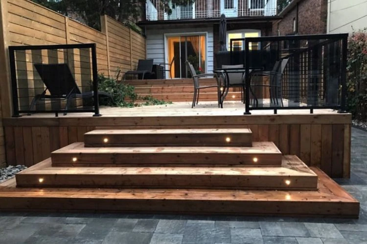 Multi-level wooden deck with built-in lighting and sturdy railings designed for year-round durability in Toronto