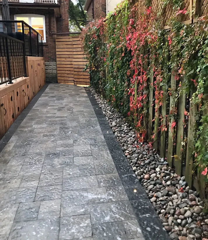 Modern outdoor space by Oaks with stone walkway and vertical garden, image by OAKS Home Services