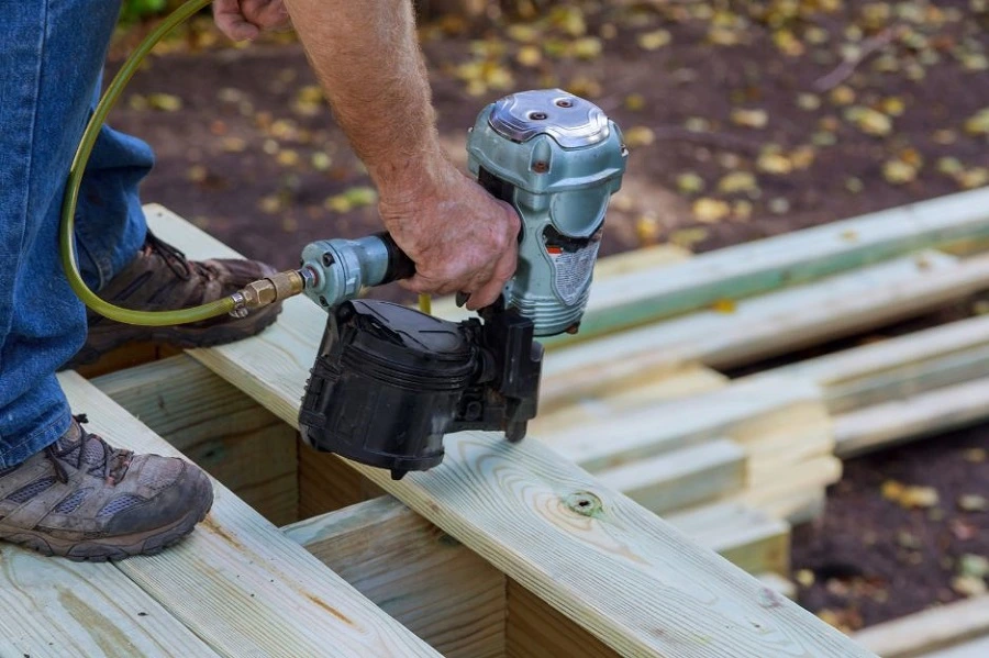 Professional deck builder securing framing boards to ensure structural safety and long-term durability