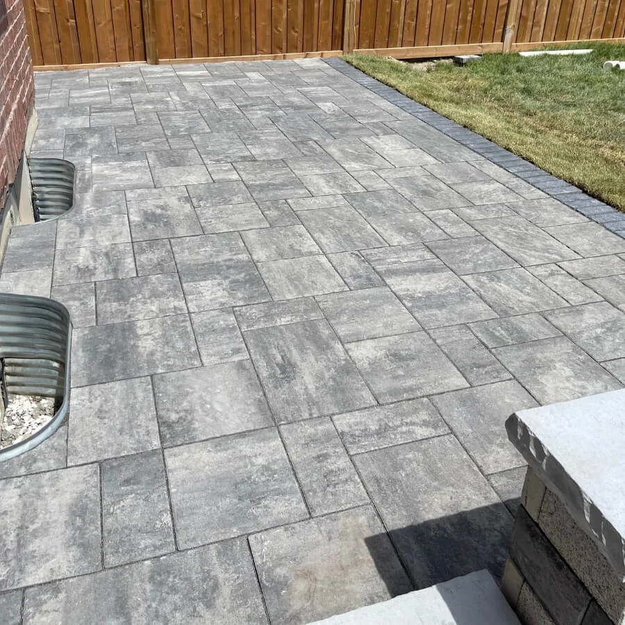 Interlocking stone patio installation with grey pavers and clean modern layout